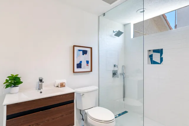 a bathroom with a sink mirror toilet and shower