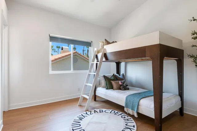 a bedroom with a bed and wooden floor