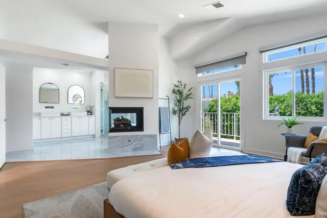 a bedroom with a large bed and a fireplace