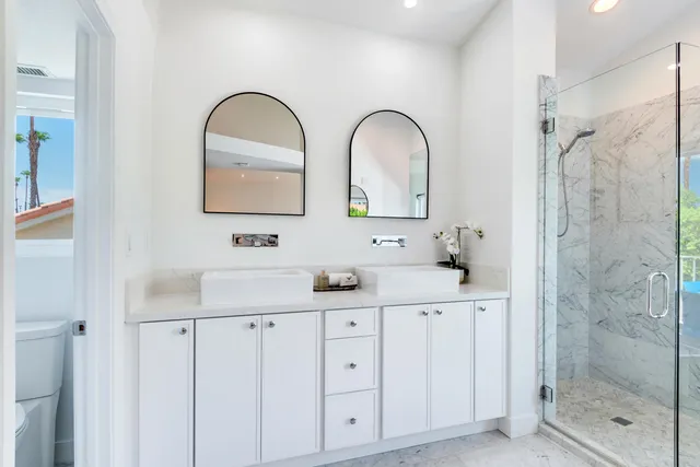 a bathroom with a double vanity sink mirror and shower
