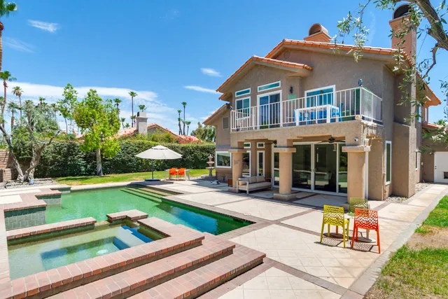 a view of a house with swimming pool and sitting area