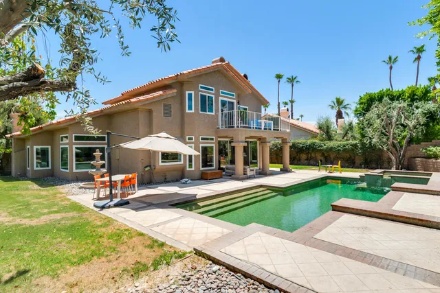 a view of a house with swimming pool and a yard