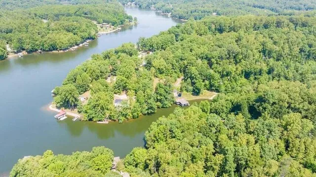 an aerial view of residential houses with outdoor space and trees