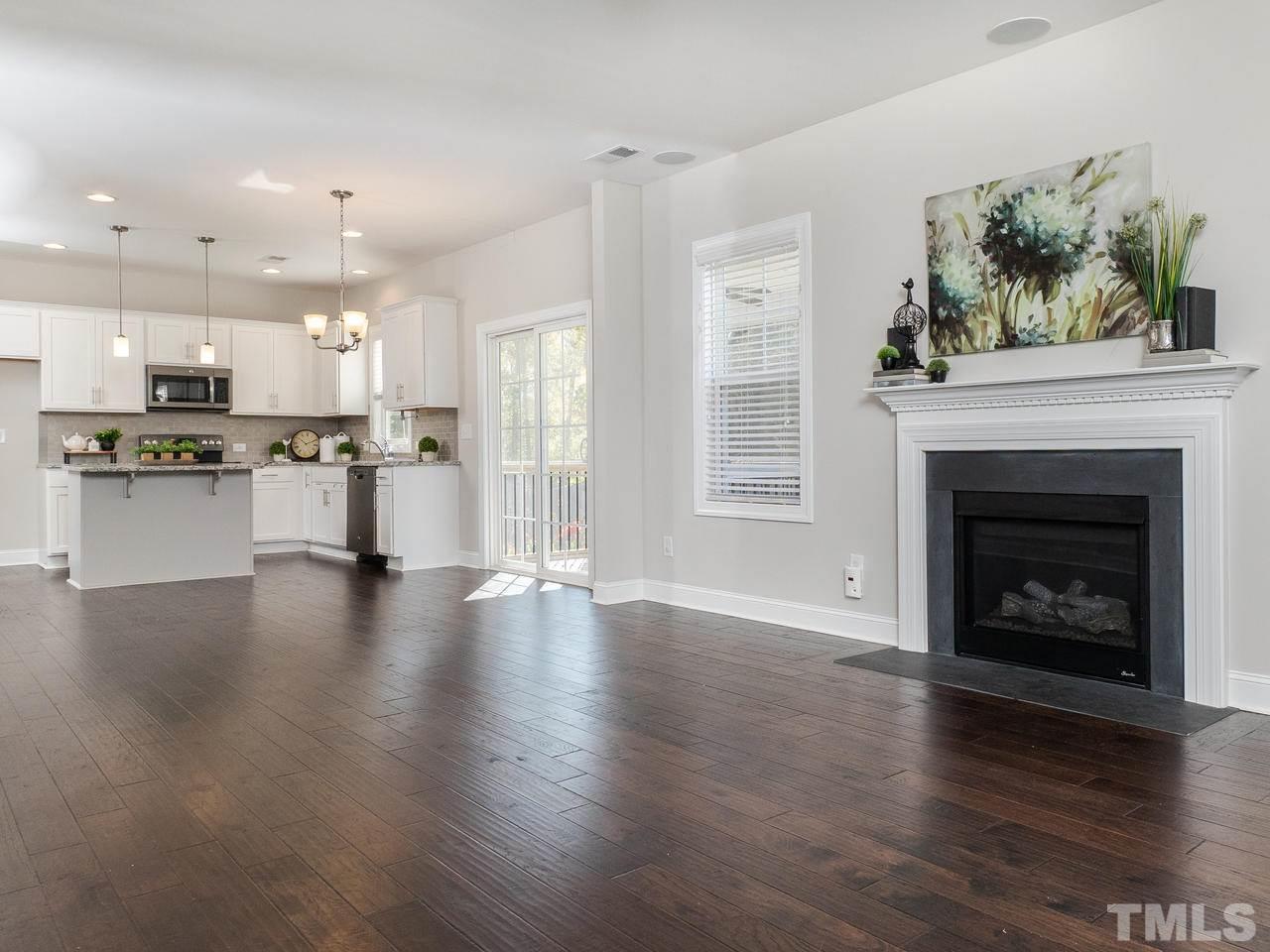 1132 Silver Farm Road Raleigh, NC 27603 - Photo 4 of 11 a view of a kitchen with a stove wooden floor and a fireplace