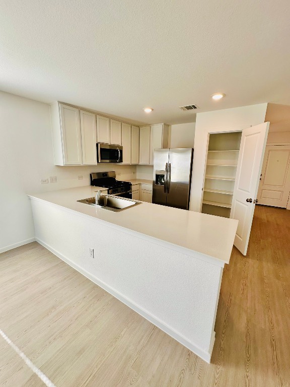 3041 Merganser Rdg Drive Katy, TX 77493 - Photo 9 of 28 a kitchen with kitchen island a stove a refrigerator a sink and a microwave