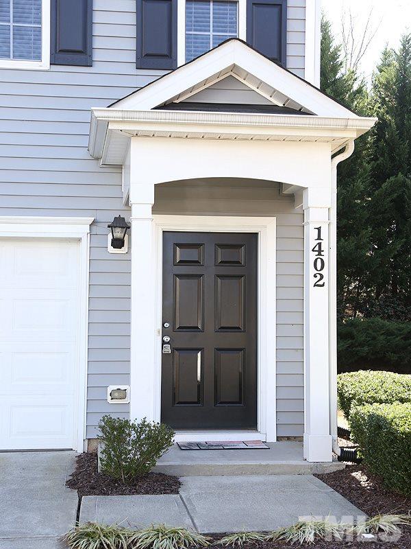 1402 Holly Grove Way Durham, NC 27713 - Photo 2 of 19 a front view of a house with a garden