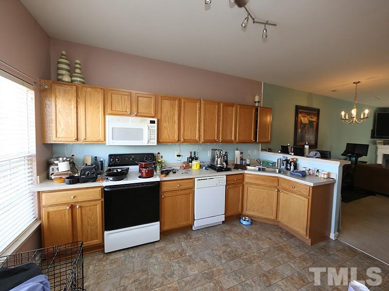 1402 Holly Grove Way Durham, NC 27713 - Photo 4 of 19 a kitchen with kitchen island granite countertop a sink cabinets and window