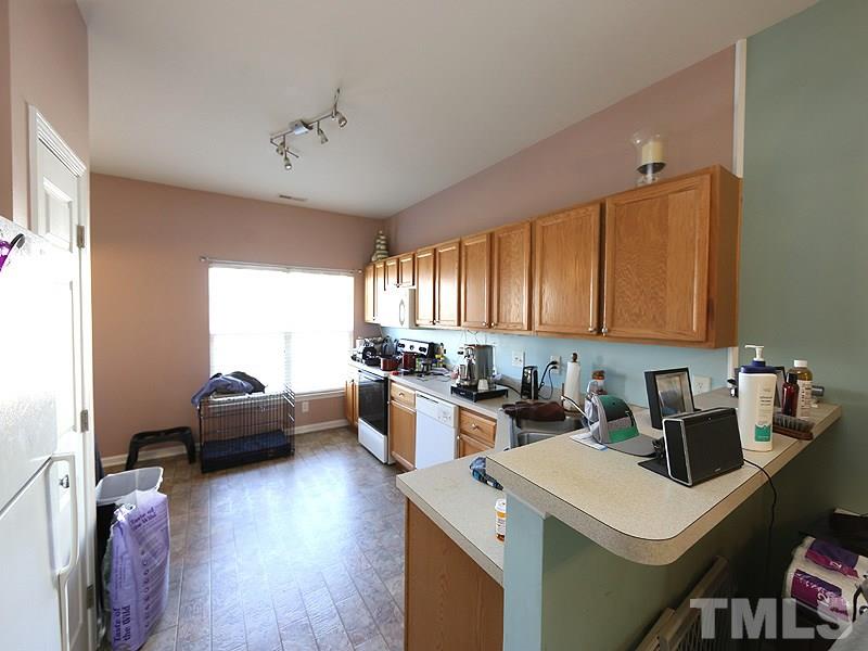 1402 Holly Grove Way Durham, NC 27713 - Photo 6 of 19 a kitchen with a stove a refrigerator and a view of living room