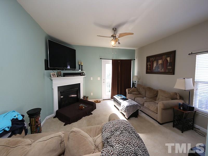1402 Holly Grove Way Durham, NC 27713 - Photo 8 of 19 a living room with furniture a flat screen tv and a fireplace