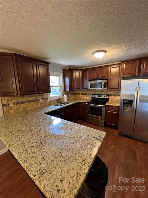 1316 Mayberry Road Dallas, NC 28034 - Photo 13 of 23 a kitchen with stainless steel appliances granite countertop a sink stove and refrigerator