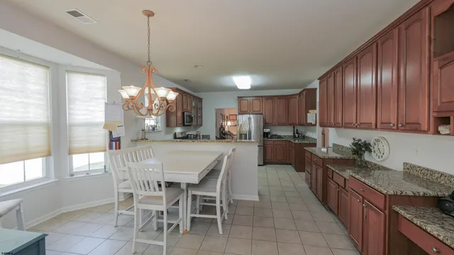 a kitchen with stainless steel appliances granite countertop wooden cabinets a stove top oven a sink and dishwasher