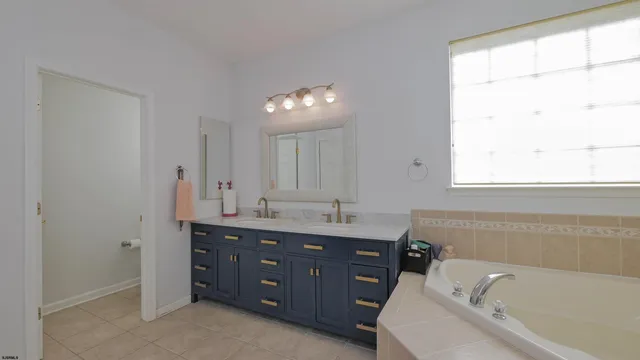 a spacious bathroom with a granite countertop tub sink and mirror