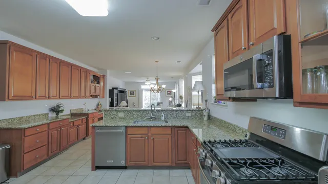 a kitchen with kitchen island granite countertop a stove a sink and a granite counter tops