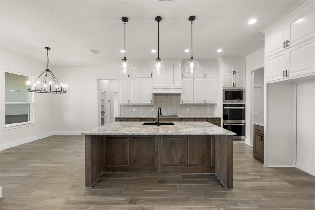4867 Prairie Sky Lane DISH, TX 76247 - Photo 10 of 27 a large kitchen with kitchen island a sink stainless steel appliances and cabinets