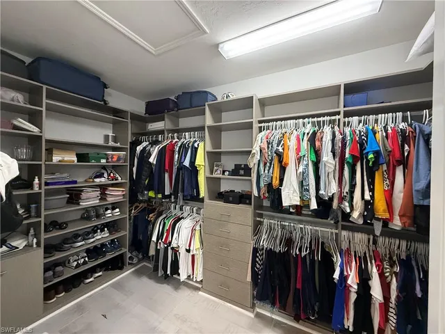 a view of walk in closet with clothes and shoes