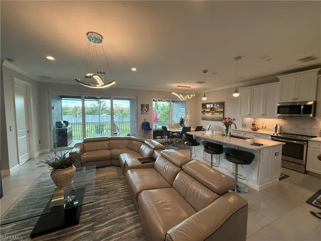 a living room with furniture kitchen and a large window