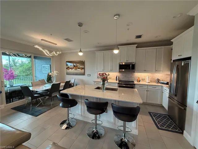 a kitchen with a dining table chairs stove and refrigerator