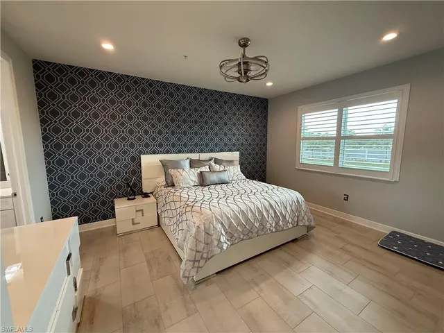 a bedroom with a bed and a chandelier