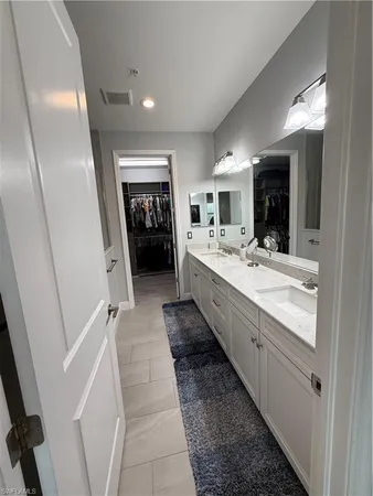 a bathroom with a double vanity sink and mirror