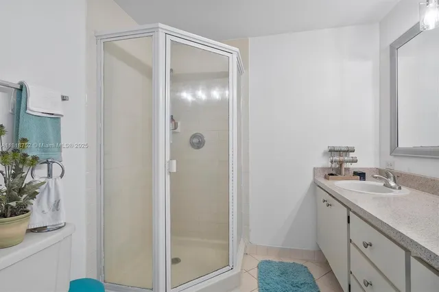 a bathroom with a shower sink and mirror