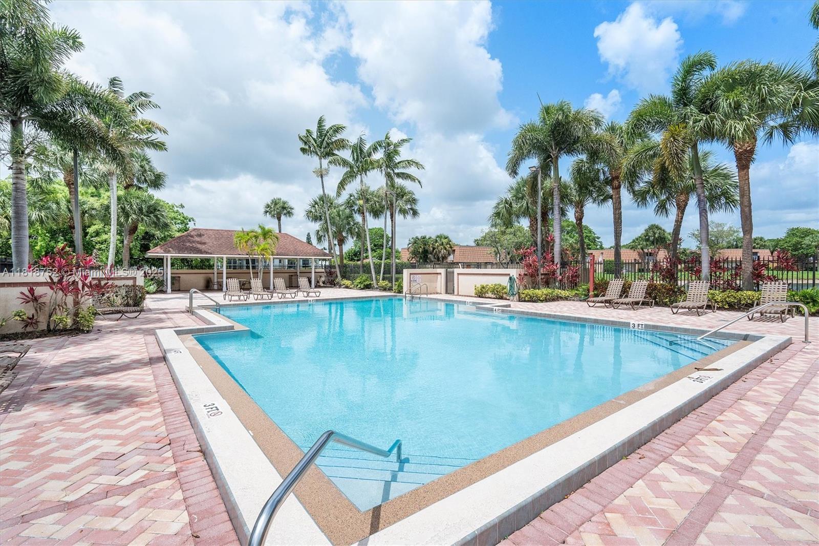 839 Blue Ridge Circle, Unit 839 West Palm Beach, FL 33409 - Photo 24 of 34 a view of a swimming pool with a lounge chairs