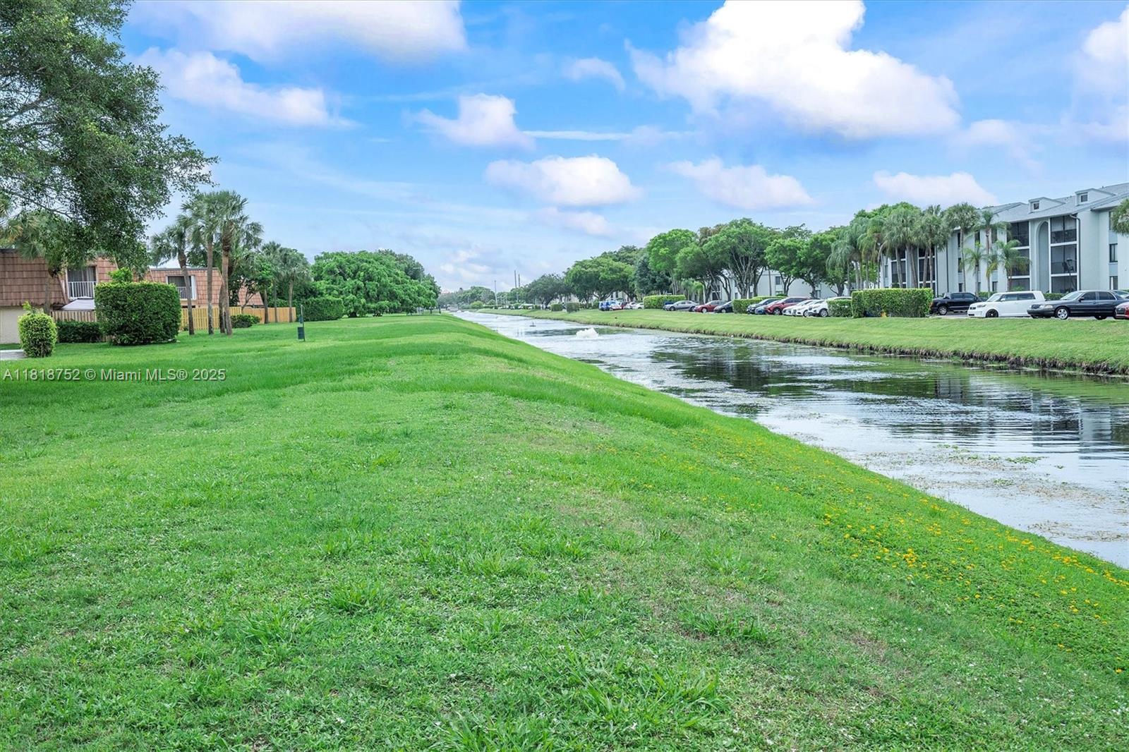 839 Blue Ridge Circle, Unit 839 West Palm Beach, FL 33409 - Photo 32 of 34 a view of a green field with wooden fence