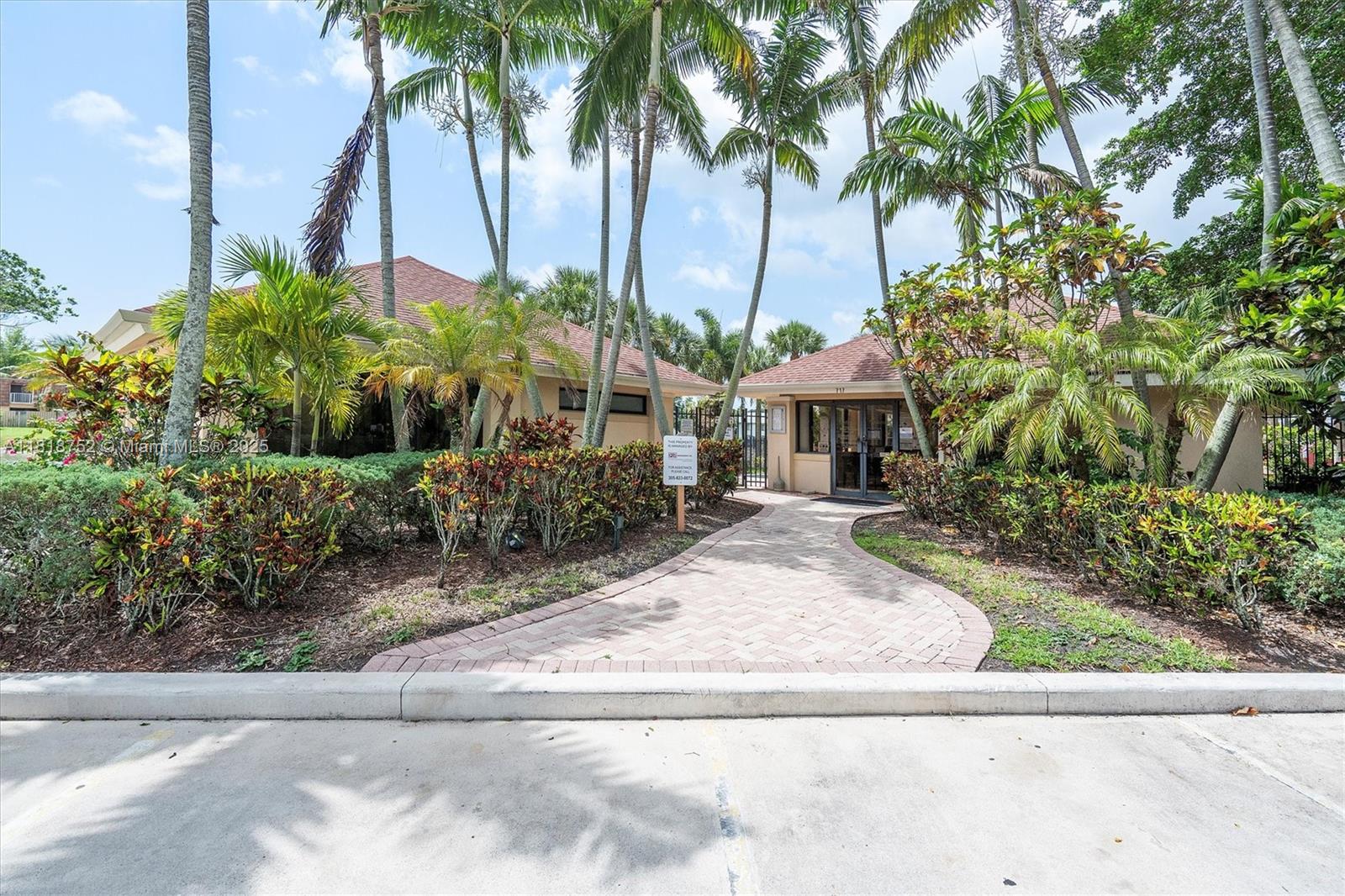 839 Blue Ridge Circle, Unit 839 West Palm Beach, FL 33409 - Photo 33 of 34 a view of a house with palm trees and a small yard