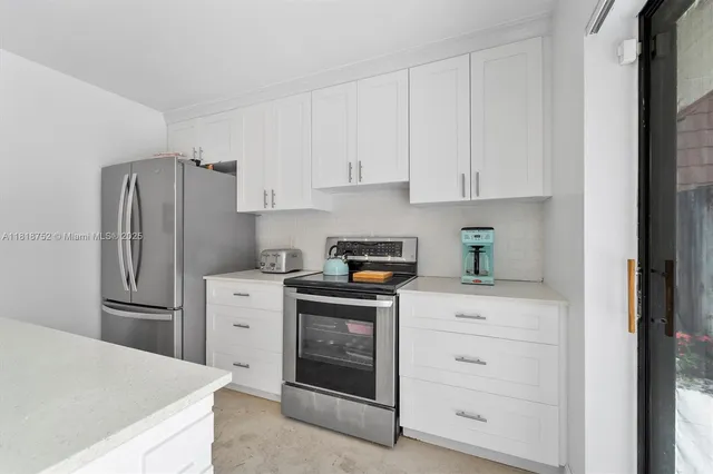a kitchen with white cabinets and stainless steel appliances