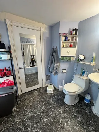 a white toilet sitting next to a bathroom sink and vanity