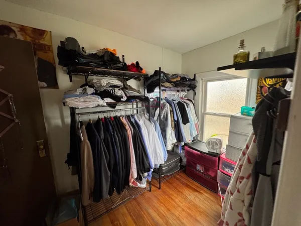a view of walk in closet with clothes and shoes