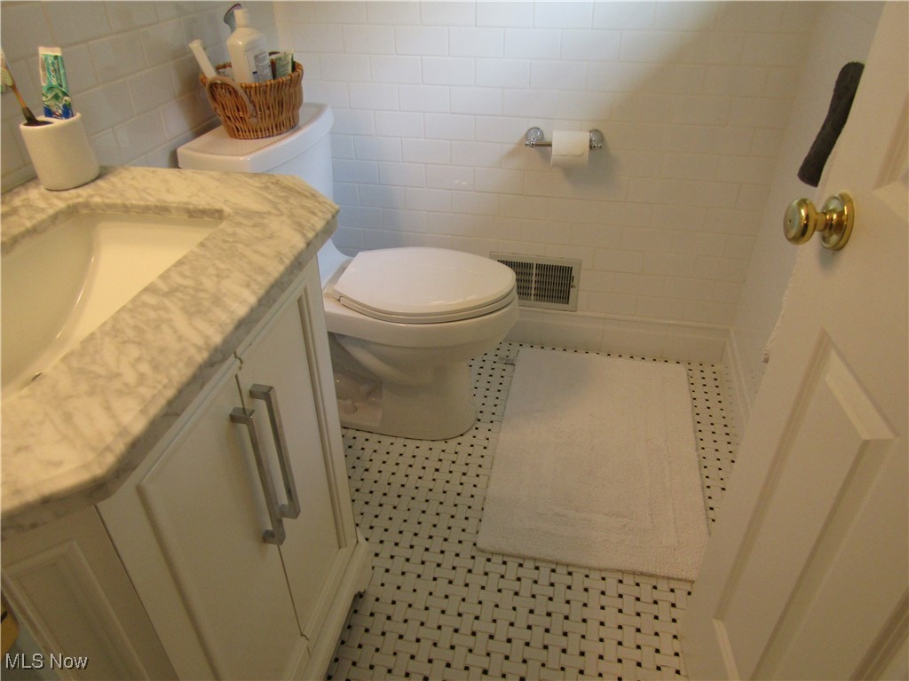 2970 Culler Road Weirton, WV 26062 - Photo 27 of 34 Bathroom featuring vanity, toilet, tile walls, and tile patterned floors