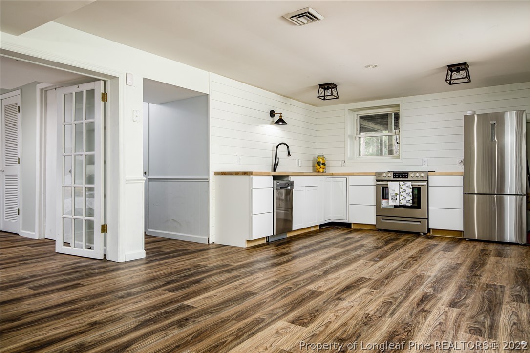 190 Valhalla Road Southern Pines, NC 28387 - Photo 34 of 39 a view of a kitchen with wooden floor electronic appliances and windows