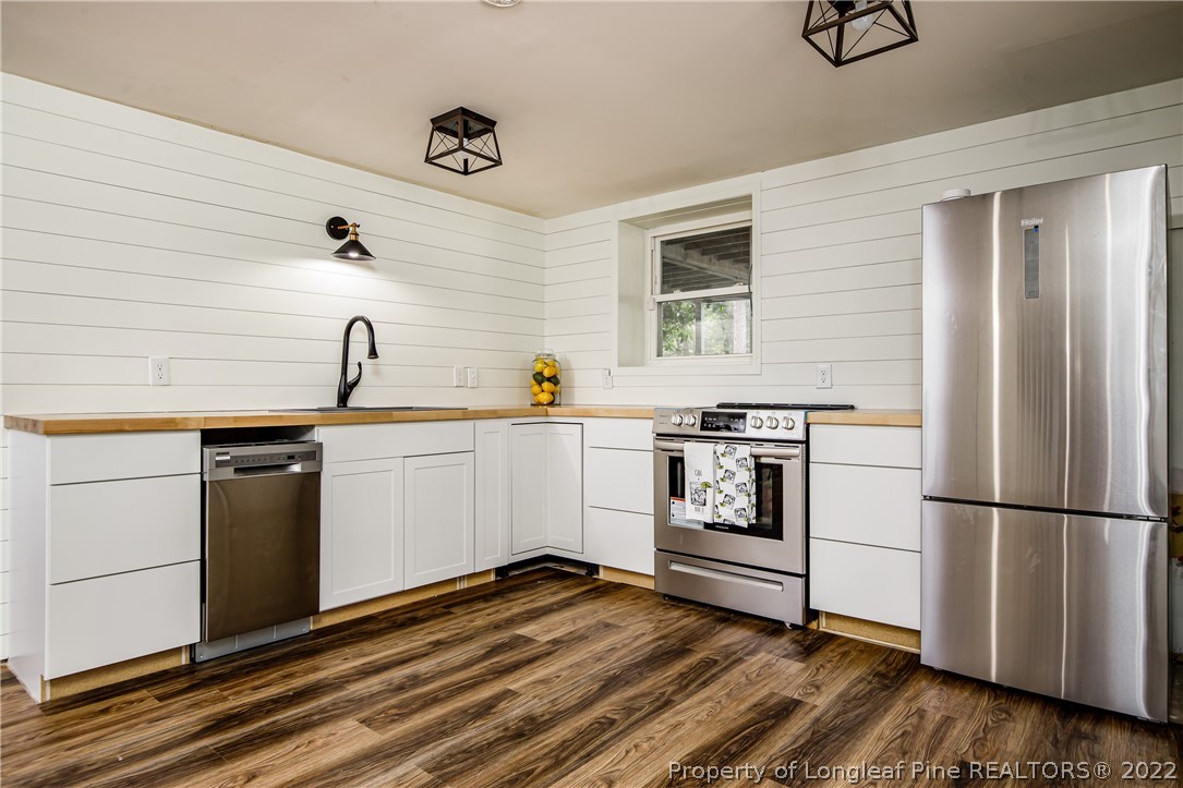 190 Valhalla Road Southern Pines, NC 28387 - Photo 35 of 39 a kitchen with a refrigerator and white cabinets