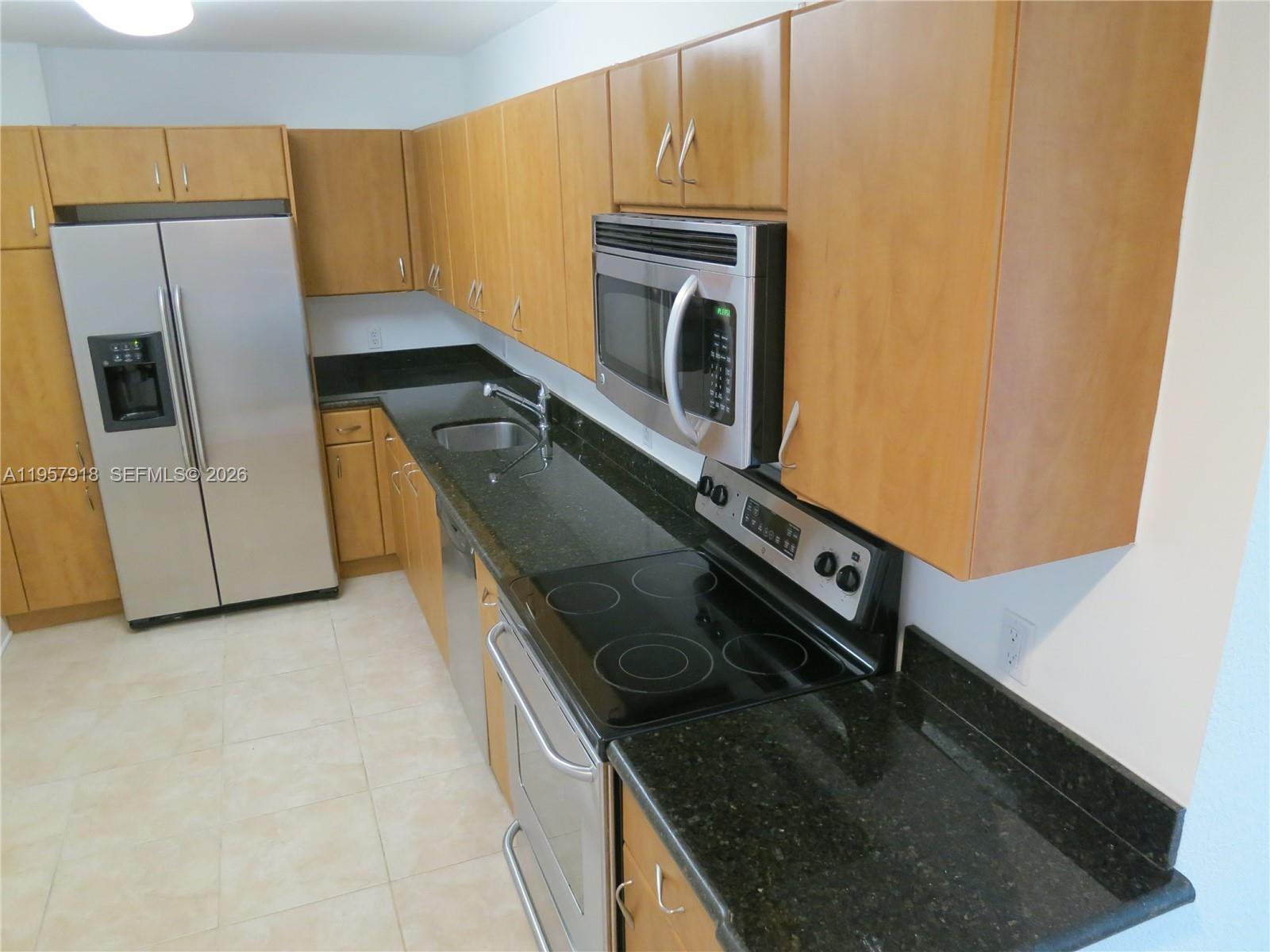 401 69th Street, Unit 906 Miami Beach, FL 33141 - Photo 2 of 24 a kitchen with a sink stove and refrigerator