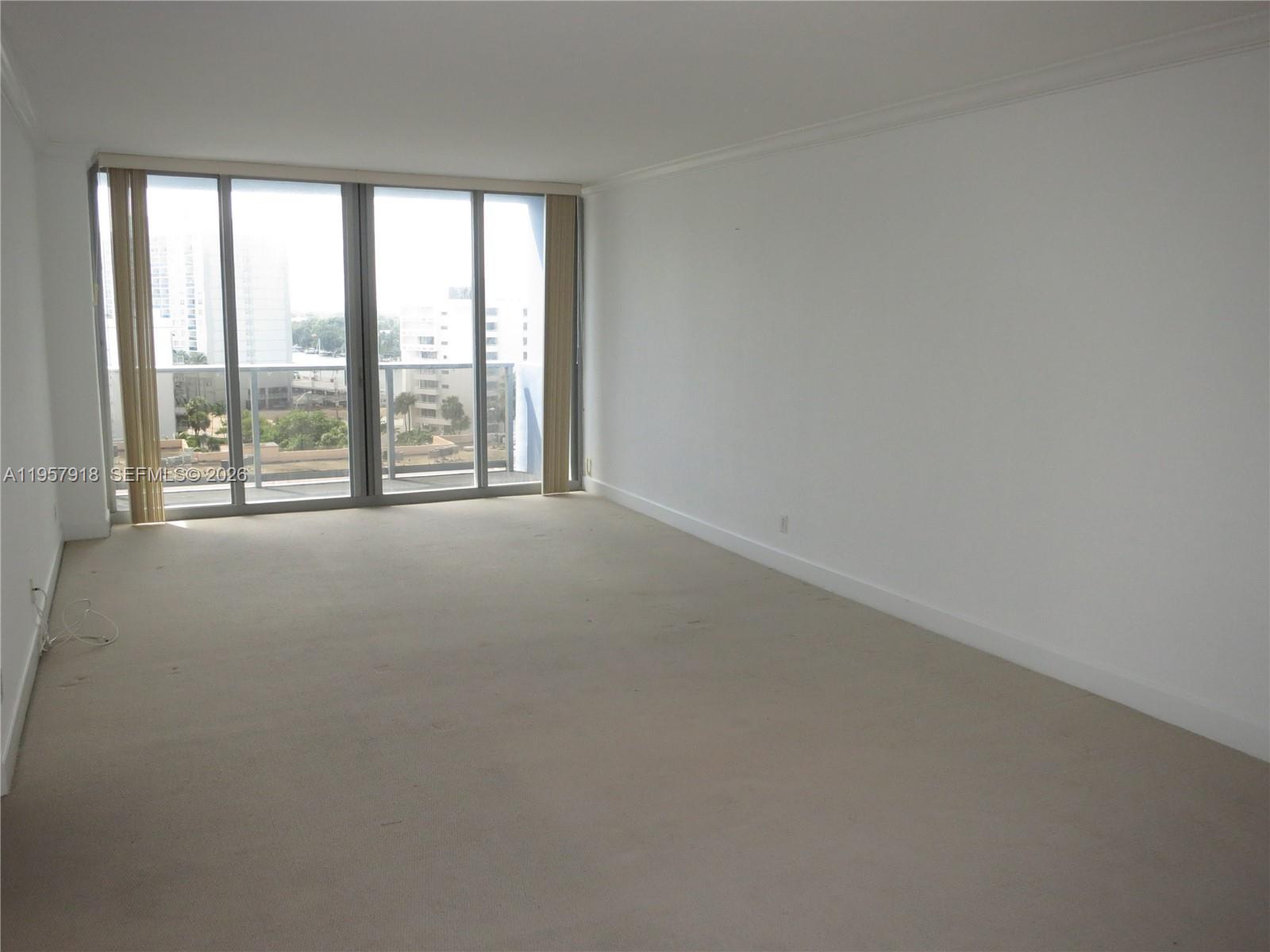401 69th Street, Unit 906 Miami Beach, FL 33141 - Photo 4 of 24 an empty room with large windows