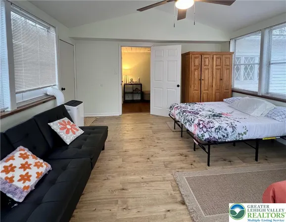 a bedroom with bed couch and window