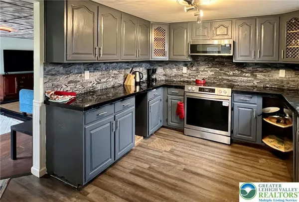 a kitchen with stainless steel appliances granite countertop a stove sink refrigerator and cabinets