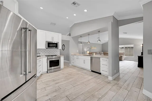 a kitchen with white cabinets and stainless steel appliances