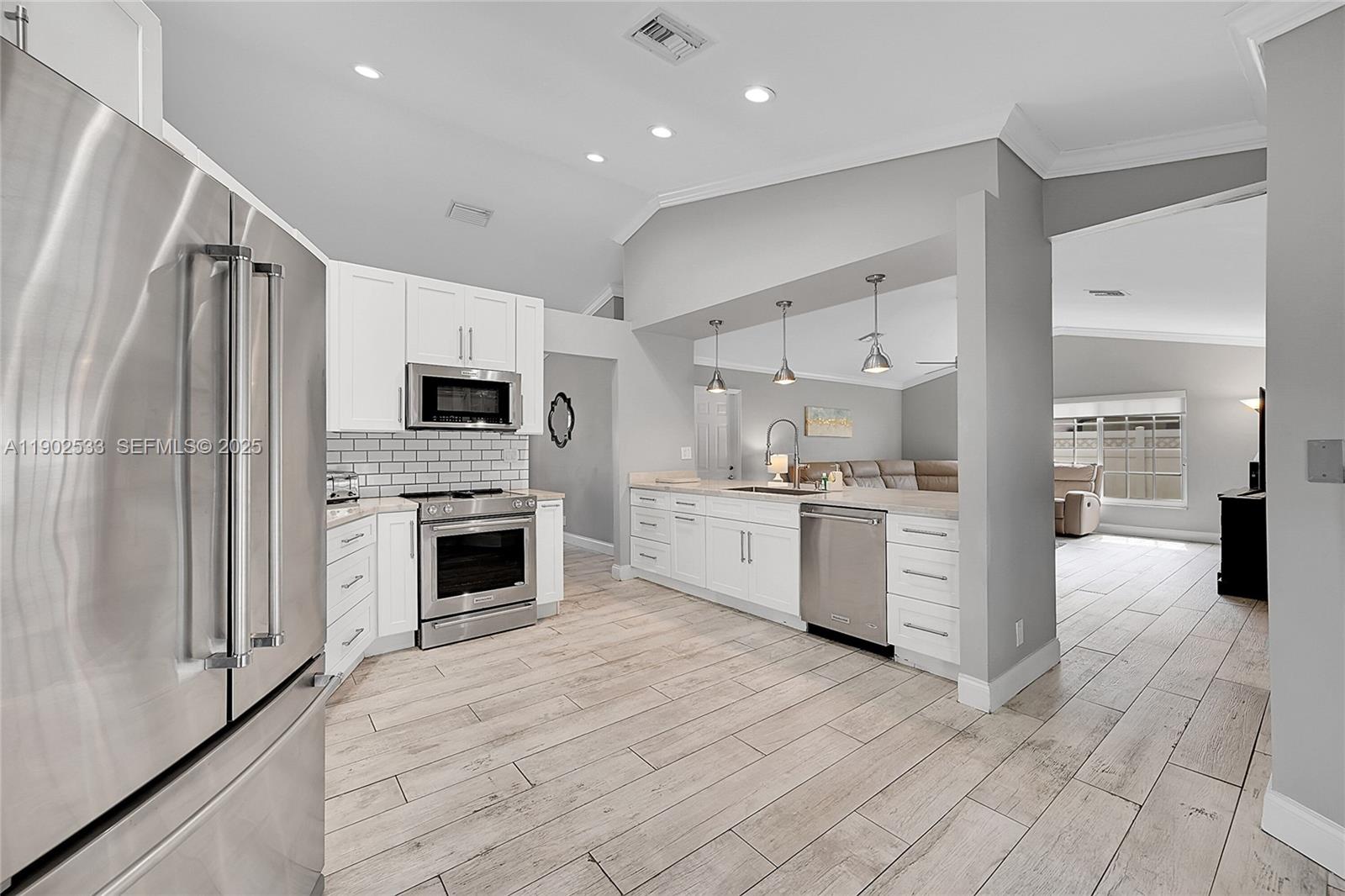 a kitchen with white cabinets and stainless steel appliances