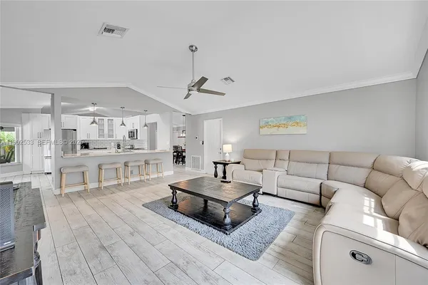 a living room with furniture and view of kitchen