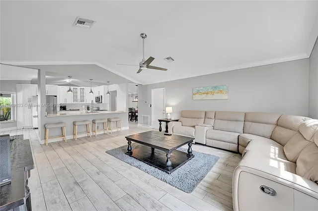 a living room with furniture and view of kitchen