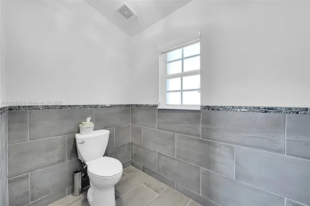 a bathroom with a toilet and a window