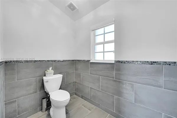 a bathroom with a toilet and a window