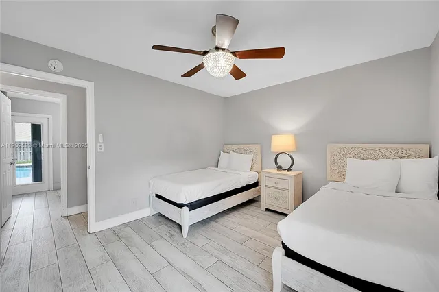 a bedroom with two large bed and a chandelier