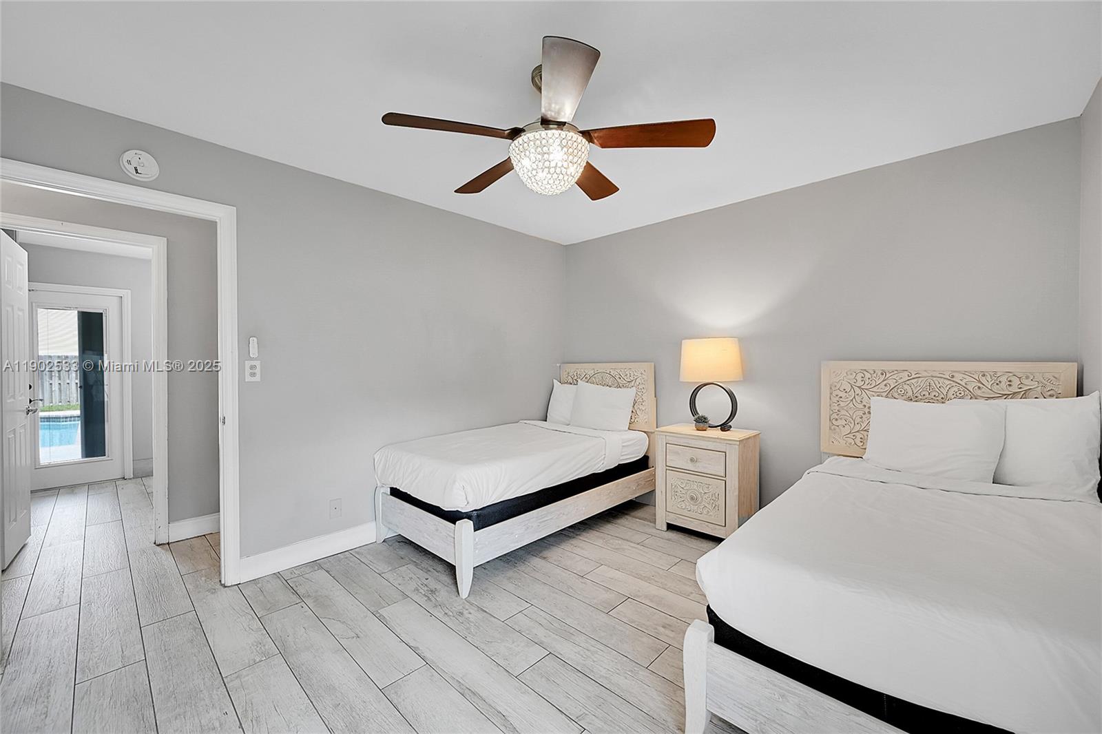 9841 Southwest 1st Street, Unit 9841 Plantation, FL 33324 - Photo 18 of 37 a bedroom with two large bed and a chandelier