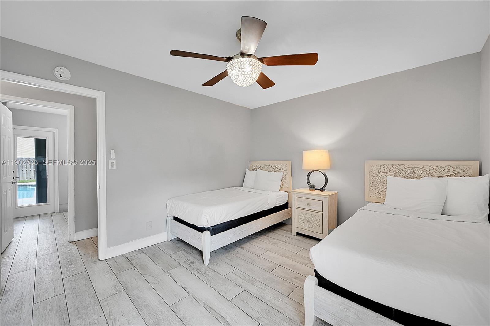 9841 Southwest 1st Street, Unit 9841 Plantation, FL 33324 - Photo 18 of 37 a bedroom with two large bed and a chandelier