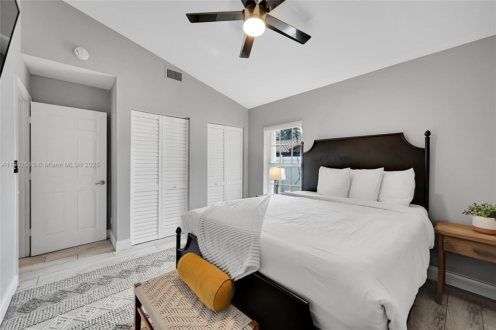 9841 Southwest 1st Street, Unit 9841 Plantation, FL 33324 - Photo 20 of 37 a bedroom with a bed and a chandelier