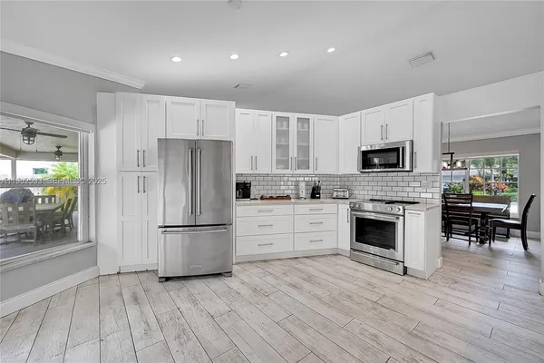 a kitchen with white cabinets and stainless steel appliances