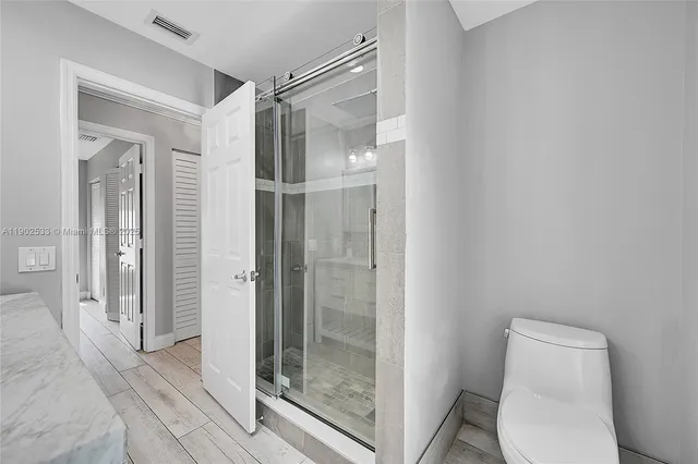 a bathroom with a shower a toilet and a sink