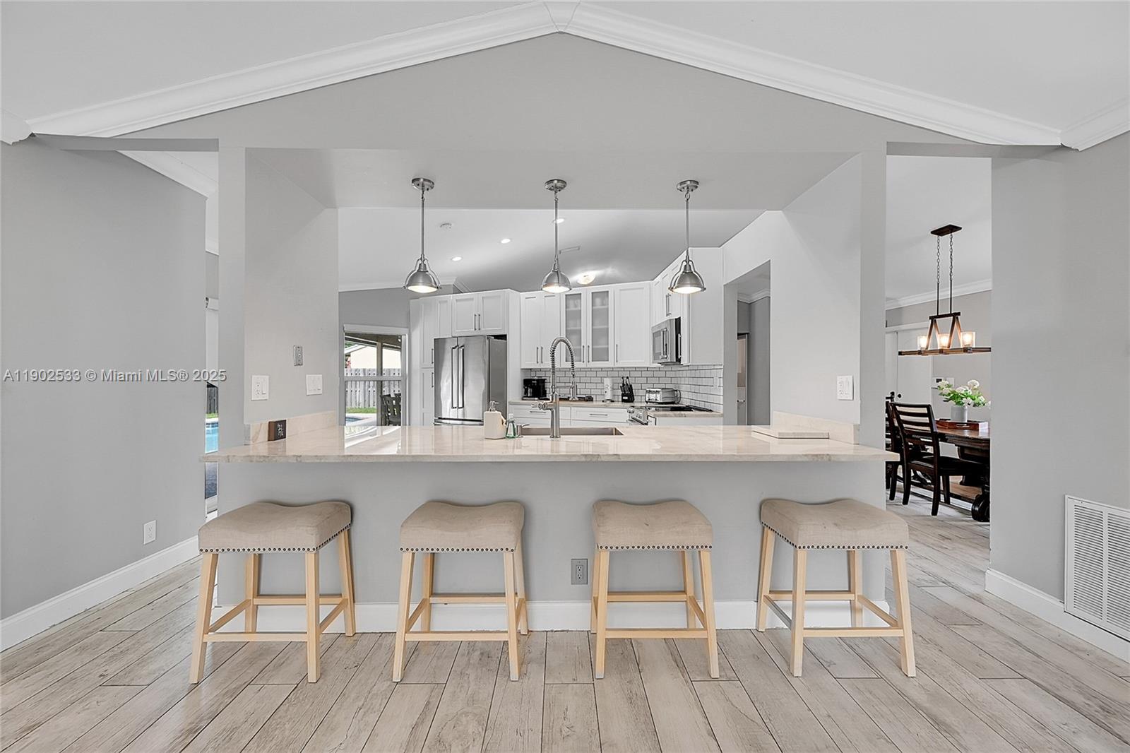 9841 Southwest 1st Street, Unit 9841 Plantation, FL 33324 - Photo 3 of 37 a kitchen with cabinets a sink dishwasher a dining table and chairs with wooden floor